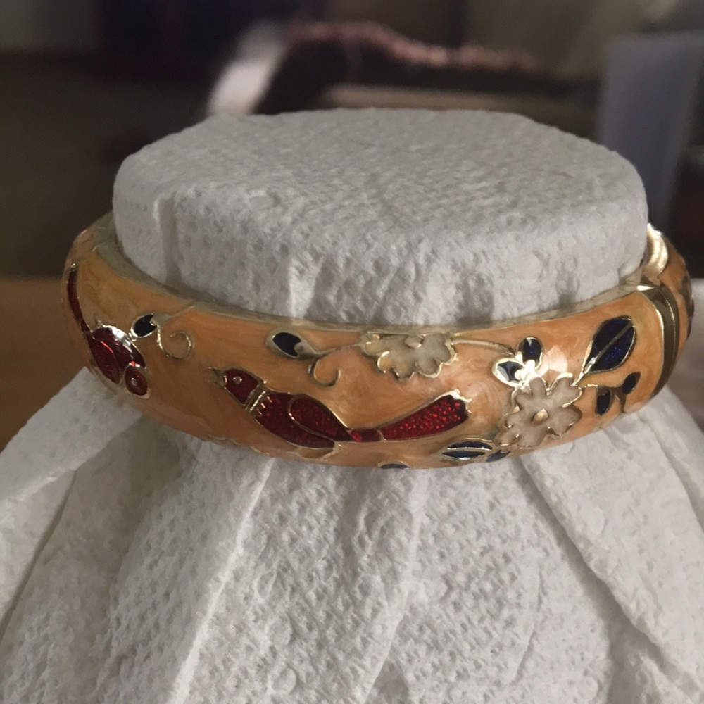 Gold tone bangle bracelet with hinged clasp.